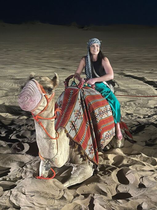 Female Tourist sitting on a camel on desert tour dubai